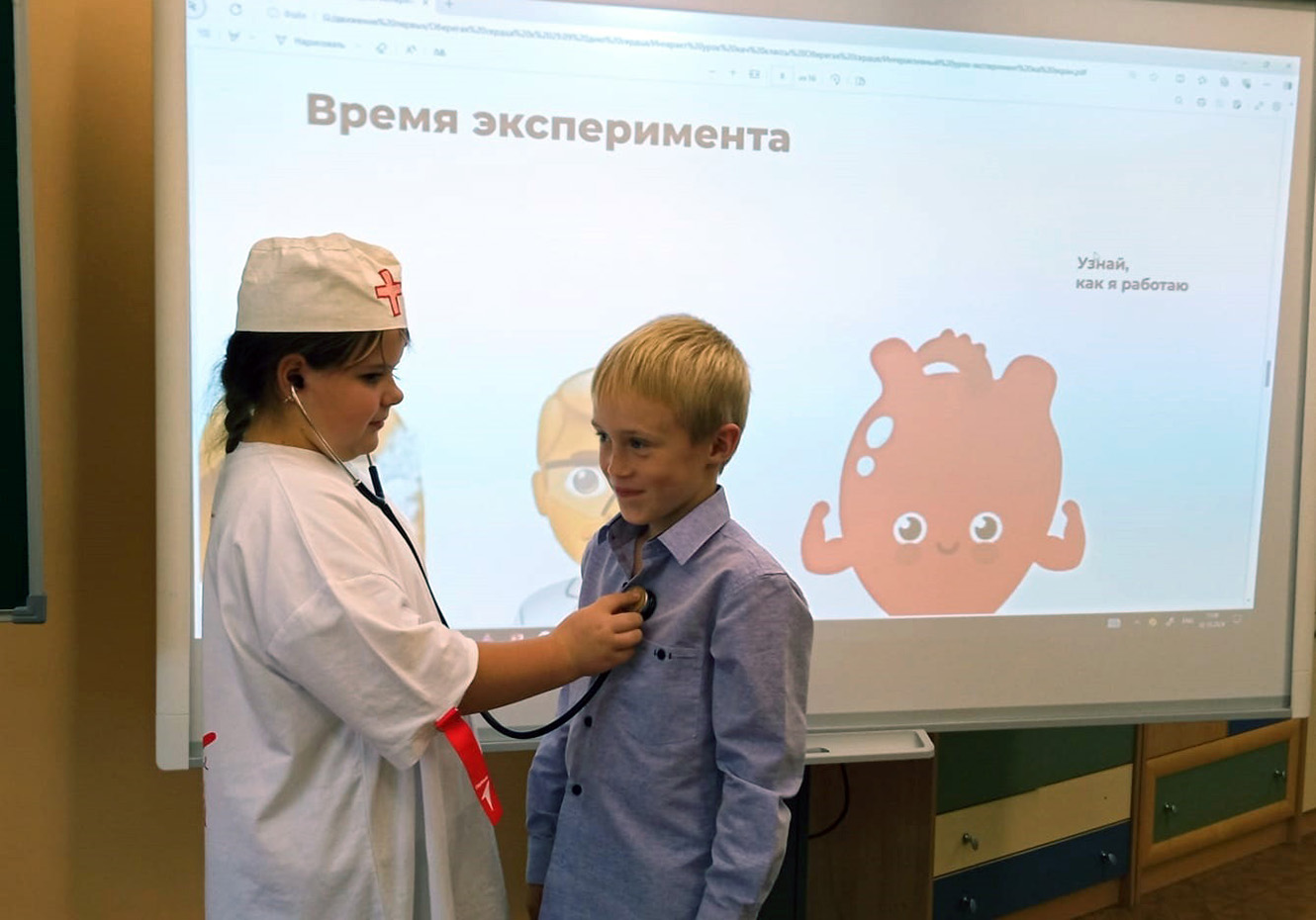 Ученица слушает сердце у одноклассника фонендоскопом | интерактивный урок-эксперимент Оберегая сердце